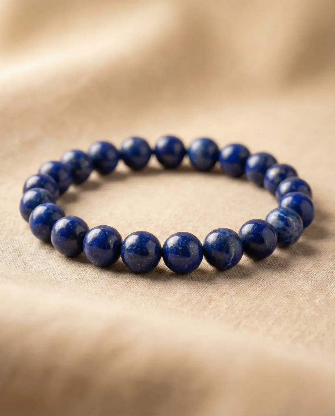 Bracelet ERA en lapis-lazuli naturel 8 mm pour homme, perles bleu intense sur fond textile clair, bijou en pierre naturelle.
