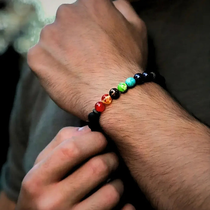 Bracelet 7 chakras pour homme sur bras croisé, accessoire spirituel