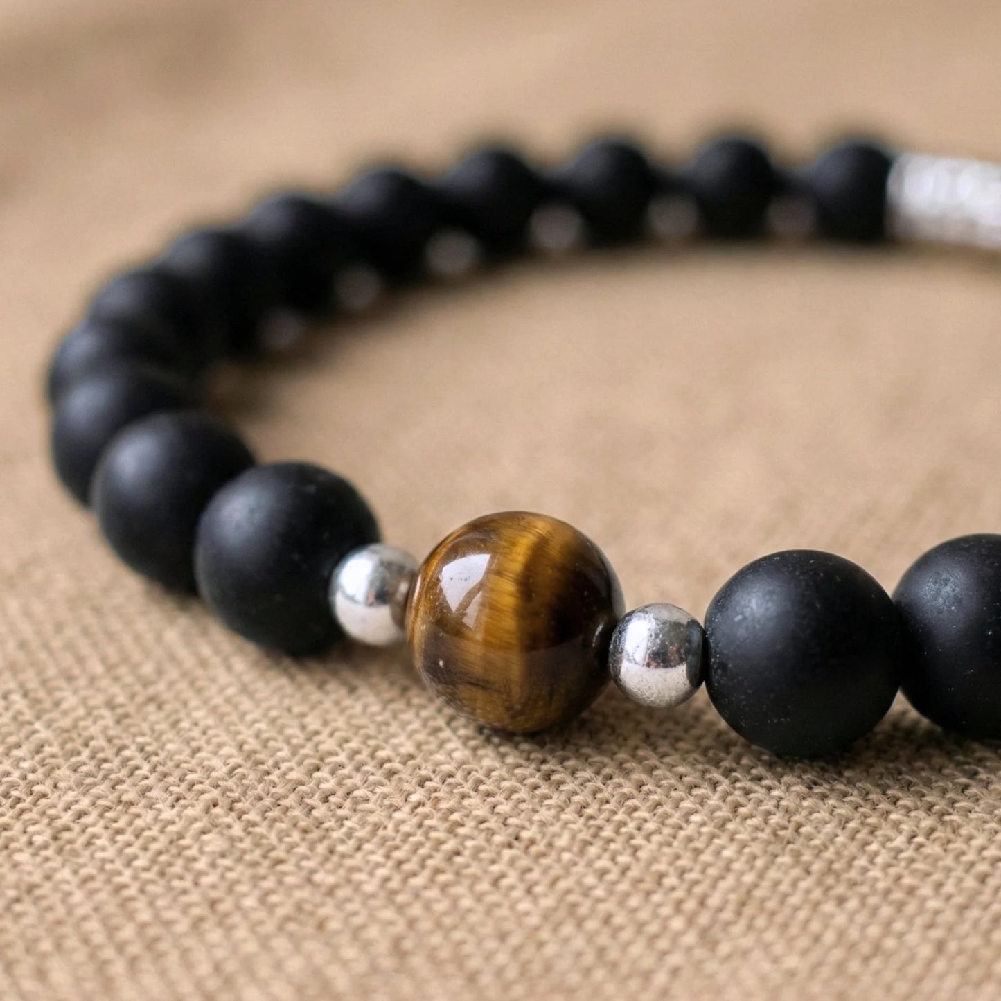 Vue rapprochée sur les pierres en oeil de tigre et onyx du duo bracelet couple distance AMORE de Antaluna.