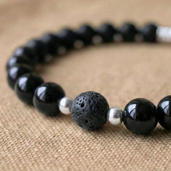 Vue rapprochée sur les pierres en pierre de lave et onyx du duo bracelet couple distance AMORE de Antaluna.