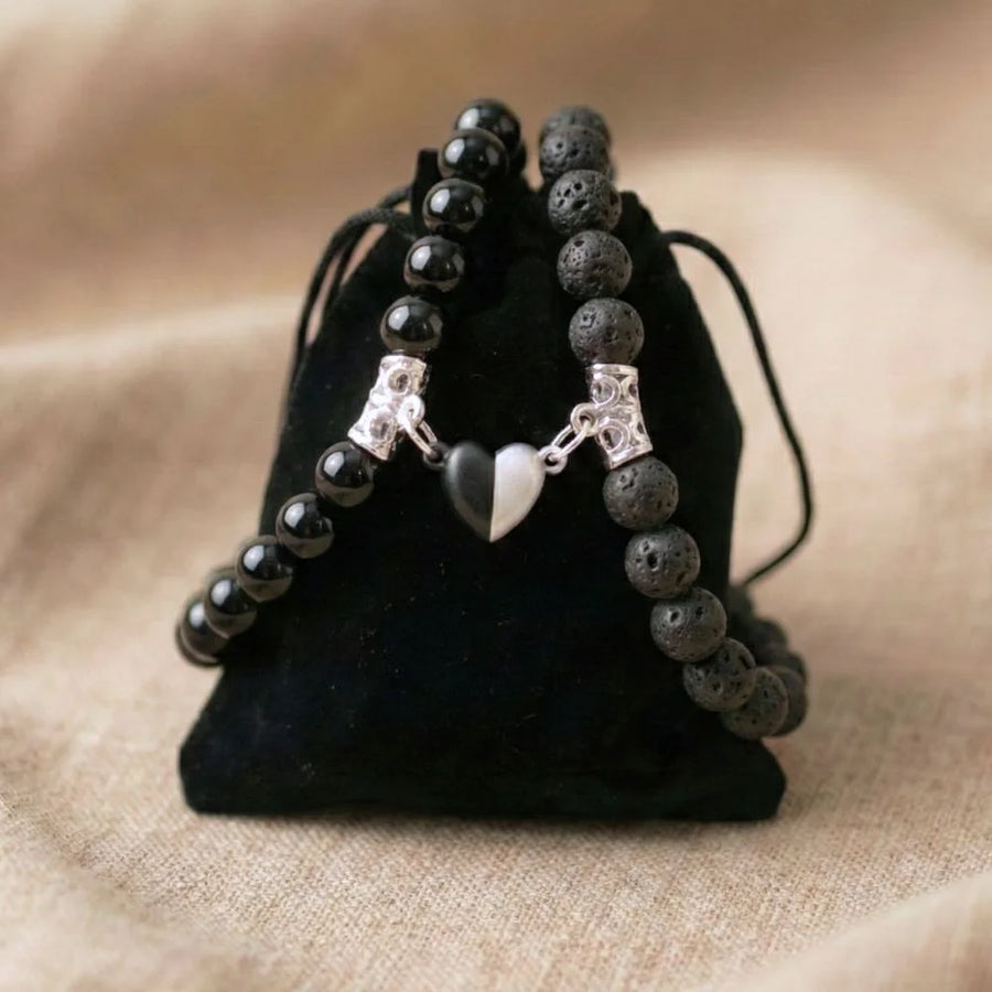 Bracelets AMORE en Pierre de lave et Onyx posé sur un pochon noir.
