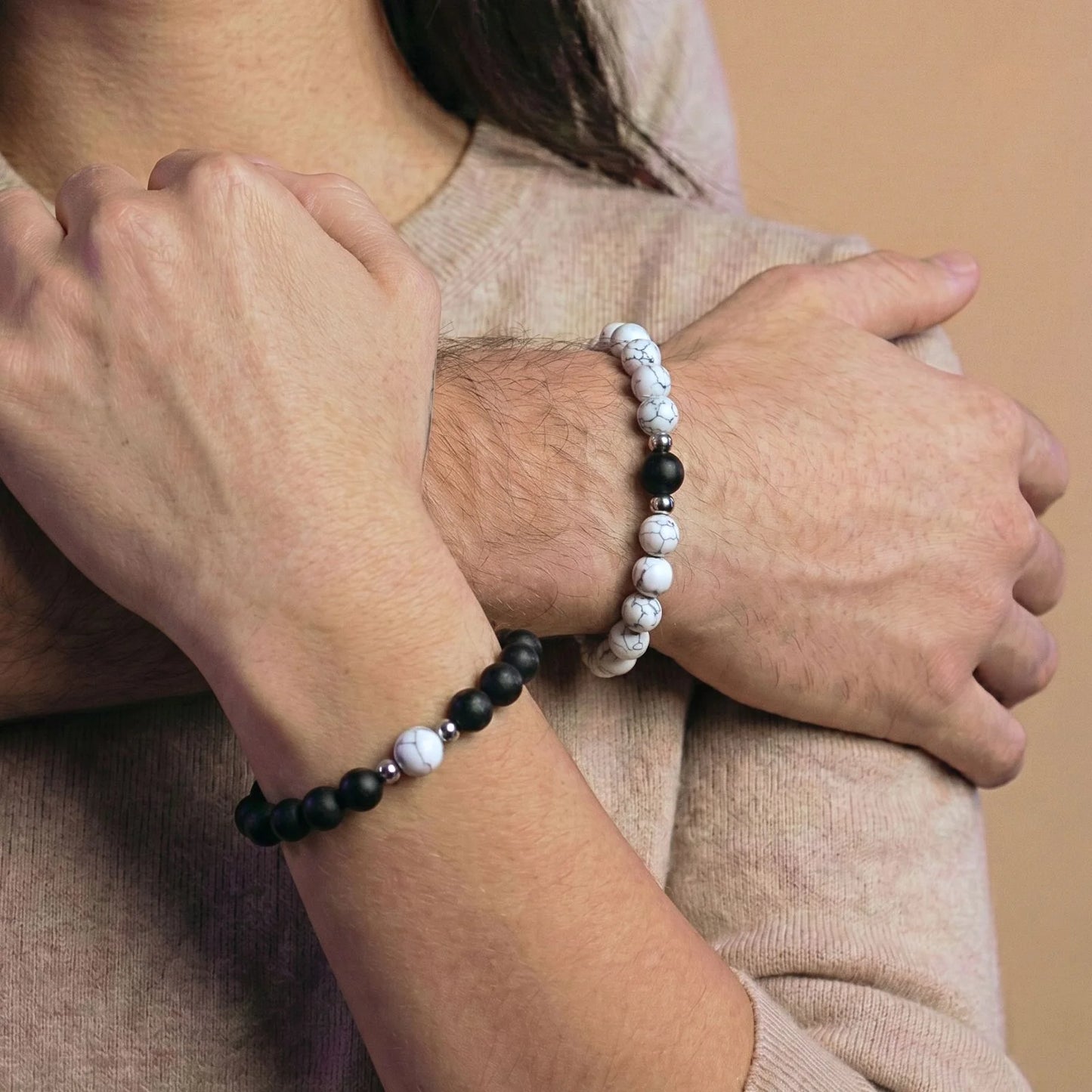 Couple enlassé et portant le duo de bracelets couple assortis blanc et noir AMORE de Antaluna