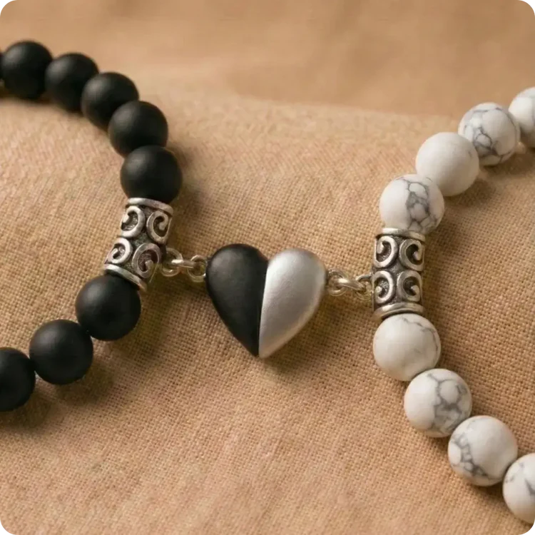 Bracelets de couple distance avec cœur magnétique. Contraste parfait entre un bracelet en perles d'Onyx noir mat et un bracelet en Howlite blanche marbrée de gris. Les deux bijoux s'unissent grâce à un fermoir aimanté en forme de cœur.