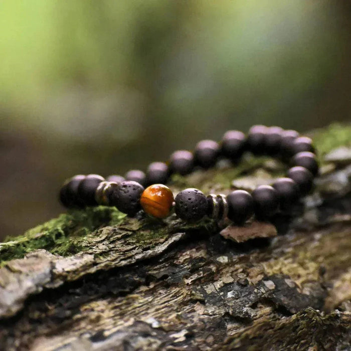 Bracelet ENERGIA pour homme avec perle en œil de tigre posé sur une pierre