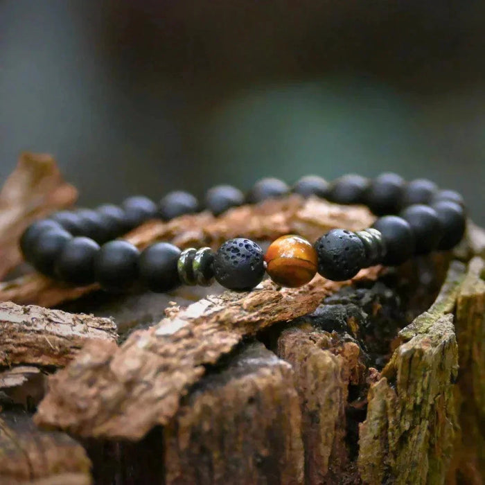 Bracelet homme en œil de tigre posé sur une souche – Collection ENERGIA