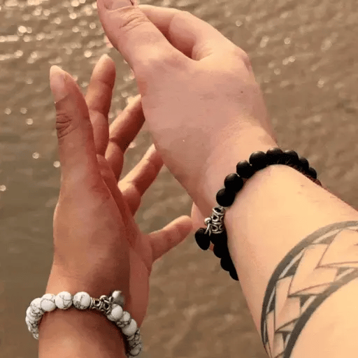 Bracelets AMORE portés par un couple – pierres naturelles Howlite et Onyx