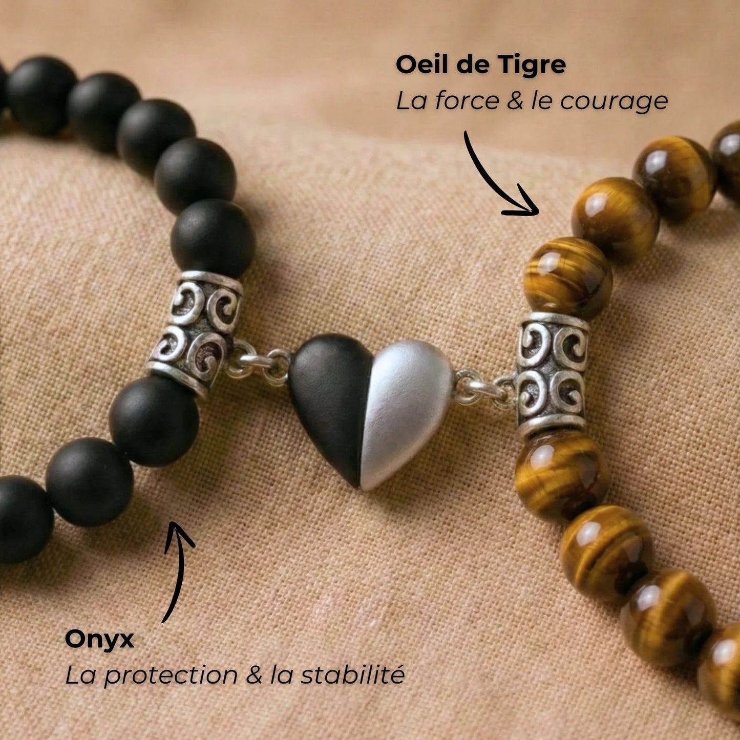 Macro sur le coeur aimanté des bracelets couple distance AMORE brun et noir avec des flèches décrivant la symbolique des pierres.
